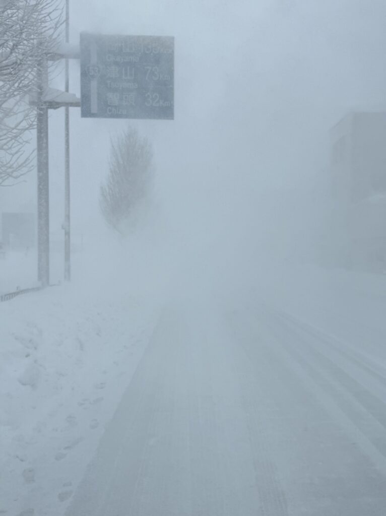 激しい雪で前方がほとんど見えない鳥取市の国道53号線の写真