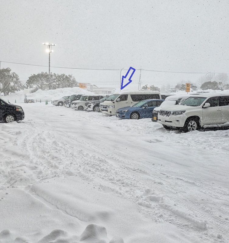 雪で覆われた鳥取市内の駐車場の写真