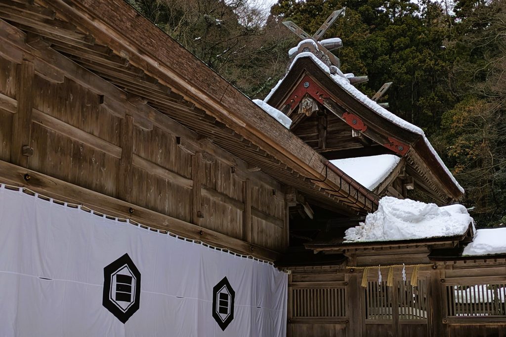 雪を被った本殿の写真