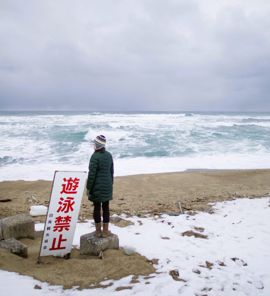 白兎海岸の海風と大荒れの波を目の前に佇むこつこつの写真