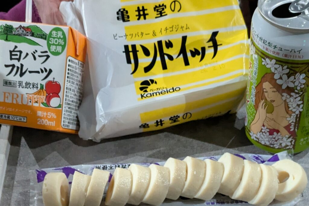 サンマート湯所店で買った亀井堂のサンドイッチと白バラフルーツ、鳥取産二十世紀梨チューハイの写真